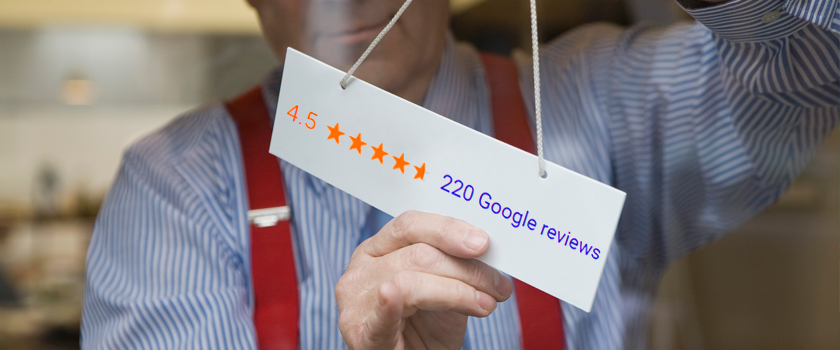 Man putting sign on business door with a 4.5 star Google review summary